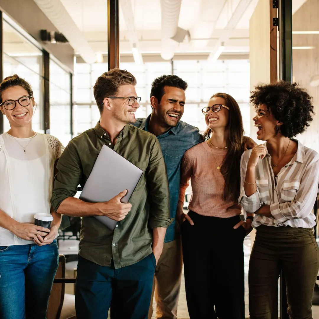 Une équipe souriante marche ensemble dans des bureaux lumineux